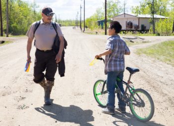 Christopher greets a young resident of Akiak on a work visit to the village.