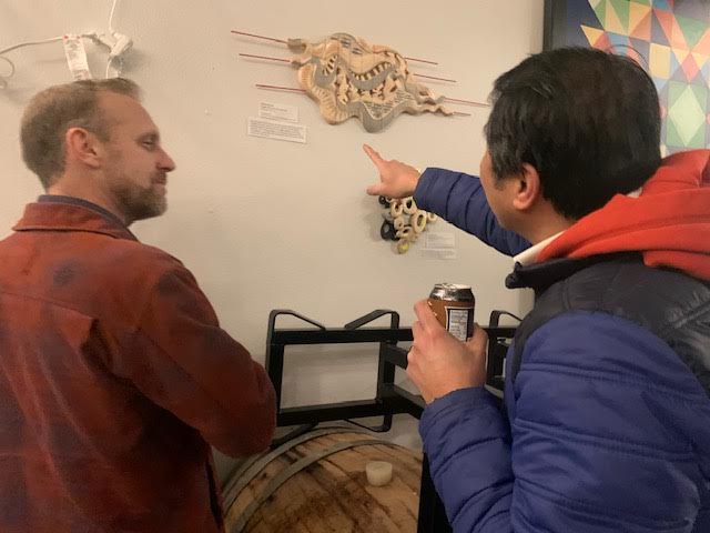 Arctic Refuge manager Merben Cebrian looking at art with Ian Wright